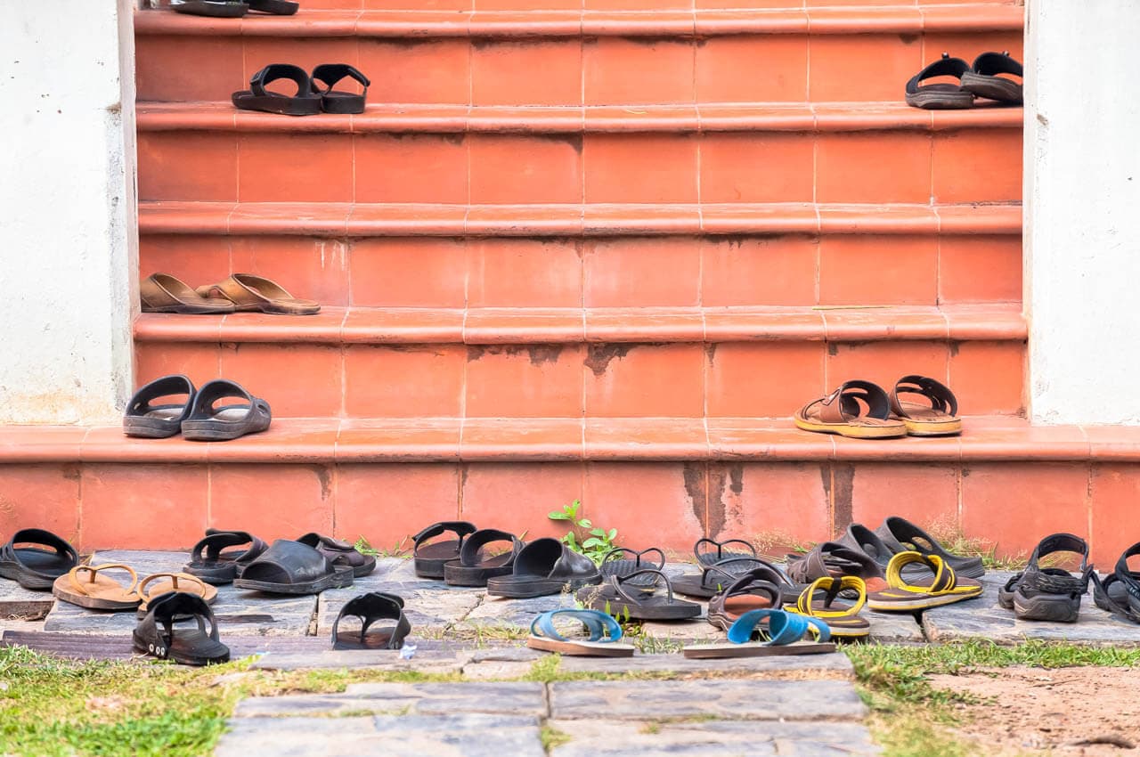Shoes neatly placed outside a traditional Thai doorstep